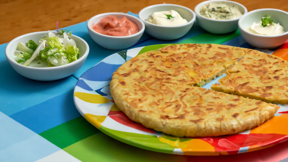 Potato tortilla cut into wedges and served with dips.