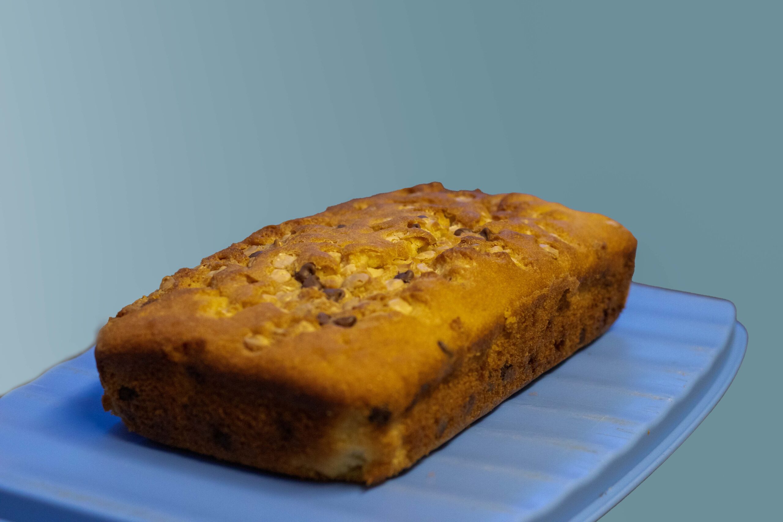 Chocolate chip loaf cake on a blue serving plate.