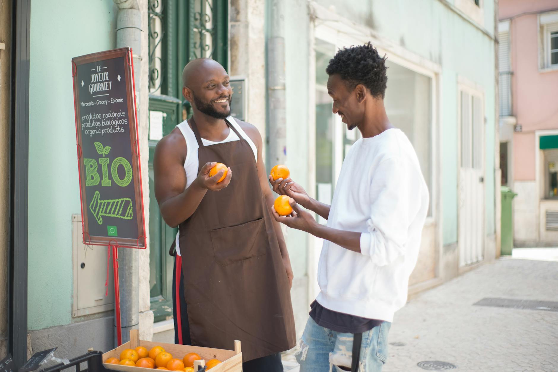 a seller talking to his customer while holding orange fruits