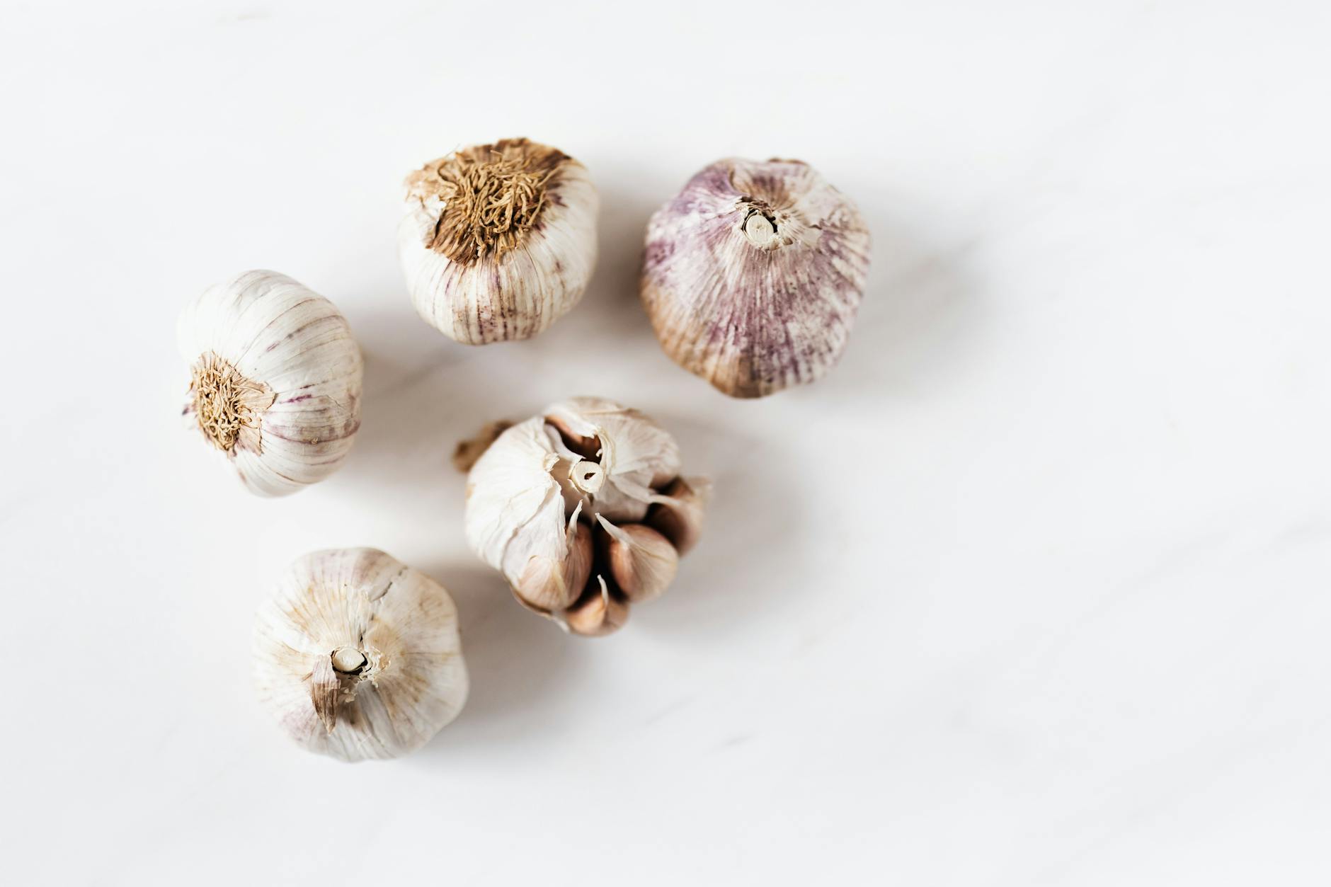 bunch of raw garlic on marble table