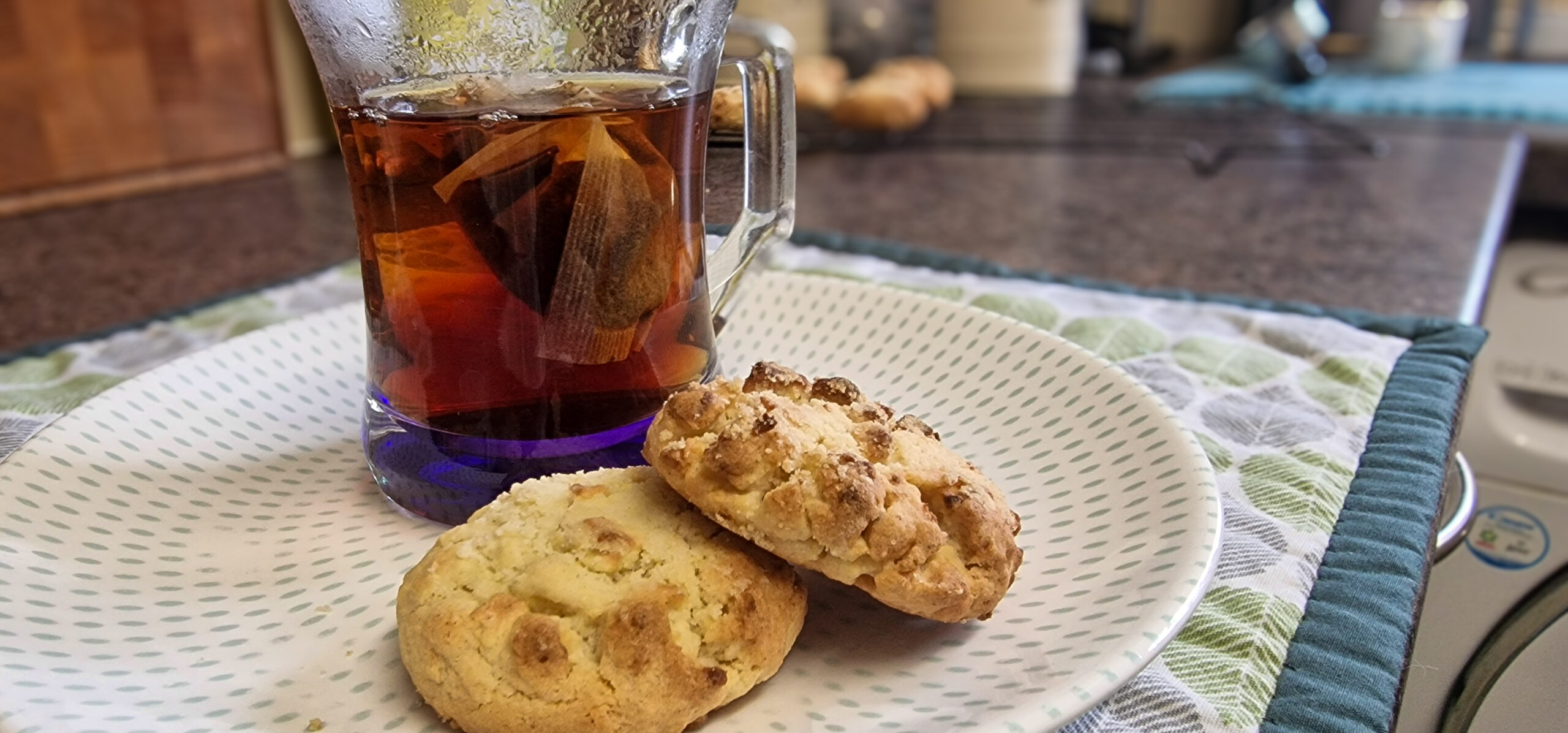 Apple crumble cookies served on a plate beside a drink.