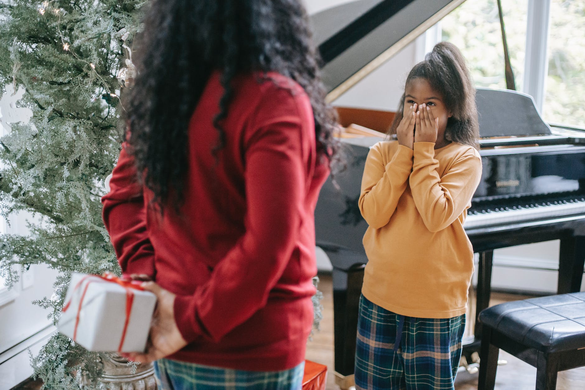 photo of a woman giving a kid a gift