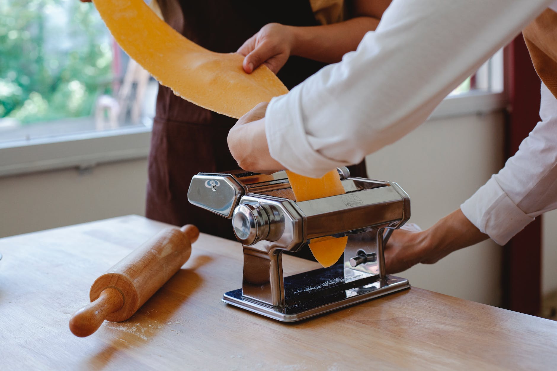 person putting dough in a pasta maker